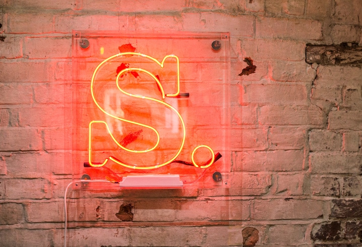 The Salad logo formed into a light, lit up in neon red