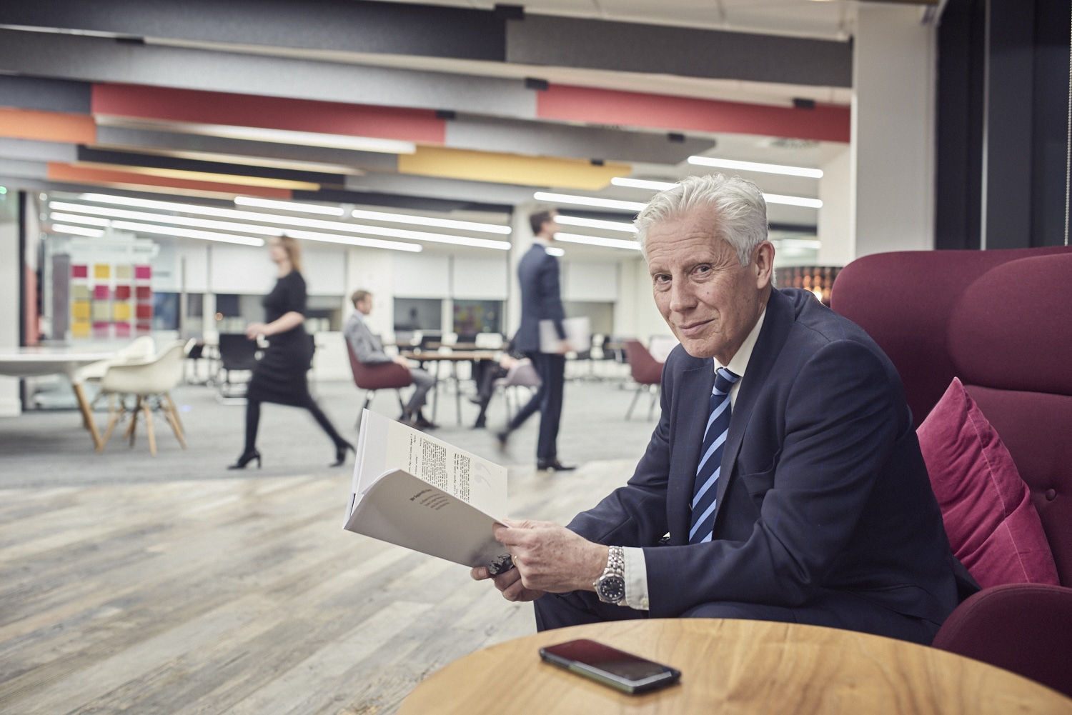 Man sitting in an armchair reading documents